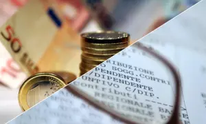 Euro in monete e banconote, con un documento che mostra voci come "contributi" e "dipendente", evocando il momento in cui viene pagata la quattordicesima.