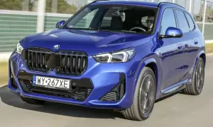 Błękitny BMW X1 2024 z dumą prezentuje swój nowy design, jadąc po drodze.