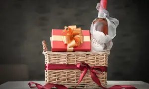 Elegancki kosz prezentowy z butelką wina i czerwonym pudełkiem, idealny jako dodatek do kosza prezentowego.
