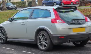 Srebrne Volvo C30 z charakterystycznym tyłem i spoilerem, zaparkowane na ulicy.