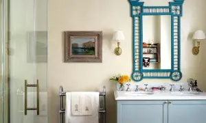 Elegante baño sin azulejos, con lavabo doble, espejo azul y cuadro de paisaje.