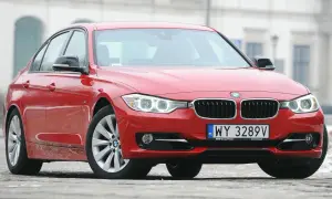 Czerwone BMW 3 F30 z polskimi tablicami rejestracyjnymi WY 3289V zaparkowane na zewnątrz.