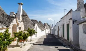 Un vicolo tra i trulli, con i loro tetti conici in pietra, mostra cosa sono i trulli, un'architettura unica della Puglia.
