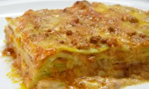 Une part de lasagne généreuse, aux couches de pâtes, sauce bolognaise et béchamel, évoquant la richesse de la lasagne origine.