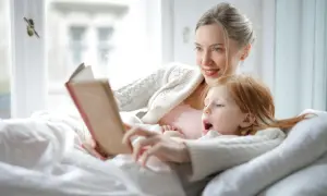 Madre e hija disfrutan de un momento acogedor con lectura en catalán para niños.