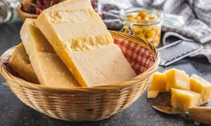 Kawałki sera Grana Padano w koszyku, obok pokrojone w kostkę. To jest właśnie to, co to jest Grana Padano.