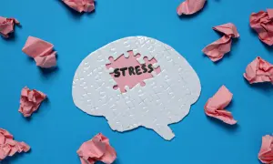 Puzzle w kształcie mózgu z napisem "STRESS" w środku. Wokół porozrzucane pomięte kartki. Jak napisać przemówienie, gdy stres paraliżuje?