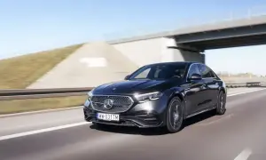Elegancki, czarny Mercedes E220d pędzi autostradą pod mostem.
