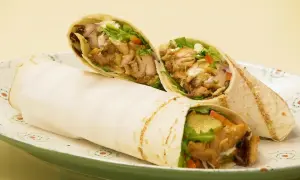 Pyszny domowy kebab w tortilli z soczystym mięsem, świeżymi warzywami i kremowym sosem. Idealny na szybki posiłek.
