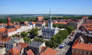 Widok na rynek i ratusz w Gąsawie. W tle widać wieżę ceglaną i rzekę. To jedne z wielu gąsawskich atrakcji.