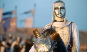 Rycerz w srebrnej masce i zbroi, z herbem Jerozolimy na płaszczu, jedzie konno. To król Baldwin IV.
