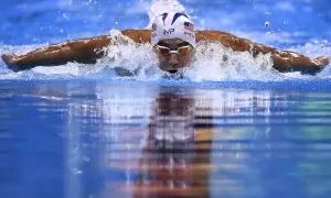 Swimmer Michael Phelps powers through the water, a blur of motion and spray. He's a master of the butterfly stroke, a style that revolutionized swimming, though who invented the butterfly stroke is debated.