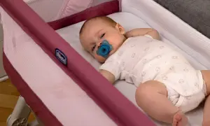 Un neonato con ciuccio dorme sereno nella sua culla, un luogo sicuro dove far dormire un neonato.