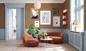 Gemütliches Wohnzimmer mit einer warmen farbpalette braun beige. Orange Sessel und Sofa laden zum Verweilen ein.