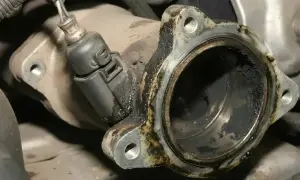 Verrußtes AGR-Ventil mit Kabelstecker. Rußablagerungen deuten auf AGR-Ventil defekt Symptome hin.