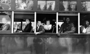 Dzieci i dorośli patrzą z okien tramwaju, uchwyceni okiem Roberta Franka.