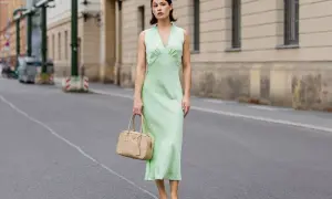 Miętowa sukienka na wesele, idealna na letnie przyjęcie. Elegancka, ale wygodna, z subtelną torebką w beżowym kolorze.