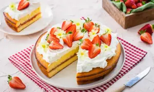 Una deliziosa torta alle fragole, con panna montata e fragole fresche, pronta per essere gustata.