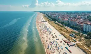 Słoneczna plaza Stogi tętni życiem. Tłumy plażowiczów, kolorowe parasole i błękitne morze tworzą wakacyjny obraz.