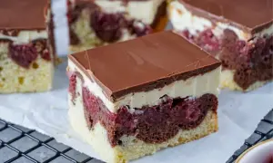 Saftiger Schneewittchenkuchen vom Blech mit Kirschen, Schokoglasur und cremiger Schicht. Ein Genuss für jeden Anlass!