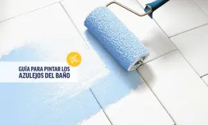 Rodillo azul pintando azulejos blancos, transformando un baño antiguo. Guía para pintar azulejos.