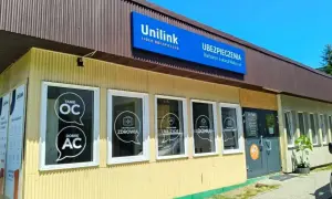 Budynek agencji ubezpieczeniowej Unilink z widocznymi na szybach hasłami: "Tanie OC", "Dobre AC", "Ubezpieczenie Zdrowia", "Na życie", "Domu".