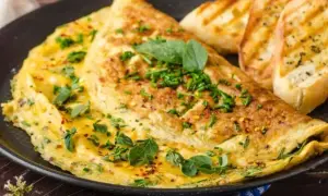 Puszysty omlet bez mąki, posypany szczypiorkiem i płatkami chili, podany z grzankami czosnkowymi. Idealne śniadanie.