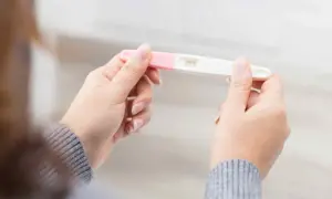 En kvinna håller ett graviditetstest. Hon är gravid trots negativt test v 7.
