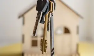 Pęk kluczy wisi na tle miniaturowego domu. Symbolizuje to nadzieję na własne cztery kąty, ale też obawy przed wywłaszczeniem.