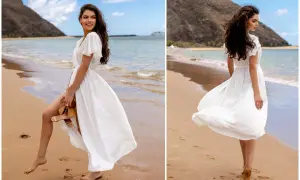 Kobieta w zwiewnej, białej sukience spaceruje po plaży. Idealne biała sukienka stylizacje na wakacje.