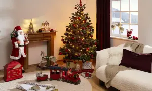 En julgran med röda kulor och ljus ger inspiration till en mysig jul. Tomten, leksakståg och en gungande häst skapar en festlig stämning.