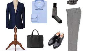 Elegancki granatowy garnitur, błękitna koszula, szare spodnie, czarne buty i aktówka – idealny zestaw, co ubrać na rozmowę kwalifikacyjną.