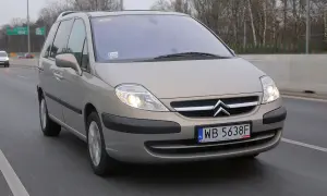 Złoty Citroën C8 na drodze, światła włączone, tablica rejestracyjna WB 5638F.
