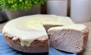 Pyszny sernik z malinami, oblany kremowym lukrem, kusi swoim wyglądem. Idealny na deser.
