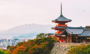 Widok na pagody i tradycyjną architekturę w Kioto, które kiedyś było stolicą Japonii. W tle rozciąga się miejski krajobraz.