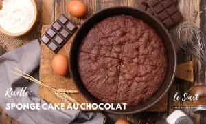 Un délicieux cake au chocolat, prêt à être dégusté, entouré d'ingrédients comme des œufs, du chocolat et de la farine.