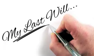 Dłoń pisze długopisem "My Last Will...", myśląc o przyszłości dzieci i testament wzajemny.
