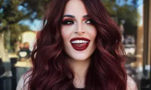 Capelli color cherry cola, labbra rosse audaci e uno sguardo malizioso.