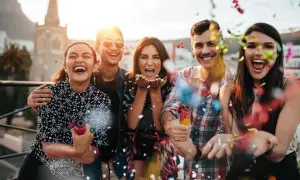 Grupa przyjaciół świętuje, wystrzeliwując konfetti. Idealne życzenia urodzinowe dla 55 latka śmieszne, pełne radości i zabawy!