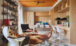 Un espacio acogedor que demuestra cómo los **mini apartamentos** pueden ser funcionales y estilosos, con cama empotrada, zona de trabajo y cómodos asientos.