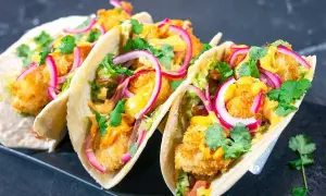 Fisktacos recept: Krispiga fiskbitar, krämig sås, rödlök och koriander i mjuka tortillabröd. En fest för smaklökarna!
