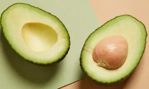 Deux moitiés d'avocat, l'une sans noyau, l'autre avec son noyau. Un aliment sain, mais attention à la prise de poids si consommé en excès.