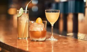 Tre läckra drinkar på en bardisk, redo att avnjutas. En med lime, en med apelsin och en i martiniglas. Perfekt för goda drinkar!