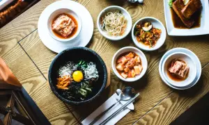 Pyszne dania kuchni koreańskiej w qb restauracji: bibimbap, kimchi i łosoś.