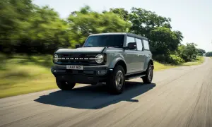 Grå Ford Bronco kör på en landsväg. Kolla in ford bronco pris för ditt nästa äventyr.