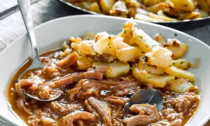 Herzhaftes Kutteln Rezept mit goldbraunen Bratkartoffeln, garniert mit Petersilie. Ein Löffel voller Genuss.