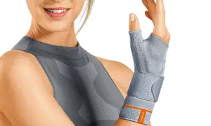 Frau mit Daumenbandage, die bei **arm verstaucht symptome** Linderung verschafft.
