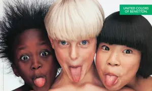 Tre bambini di etnie diverse, in una delle fotografie famose a colori di Oliviero Toscani, fanno la linguaccia.