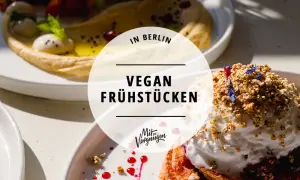 Leckeres veganes Frühstück in Berlin: Hummus, Beeren und ein süßer Traum mit Nüssen und Blüten.