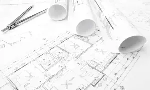 Plany budynków, gdzie szukać inspiracji i rozwiązań architektonicznych. Rysunki techniczne, cyrkiel i rolki z projektami.